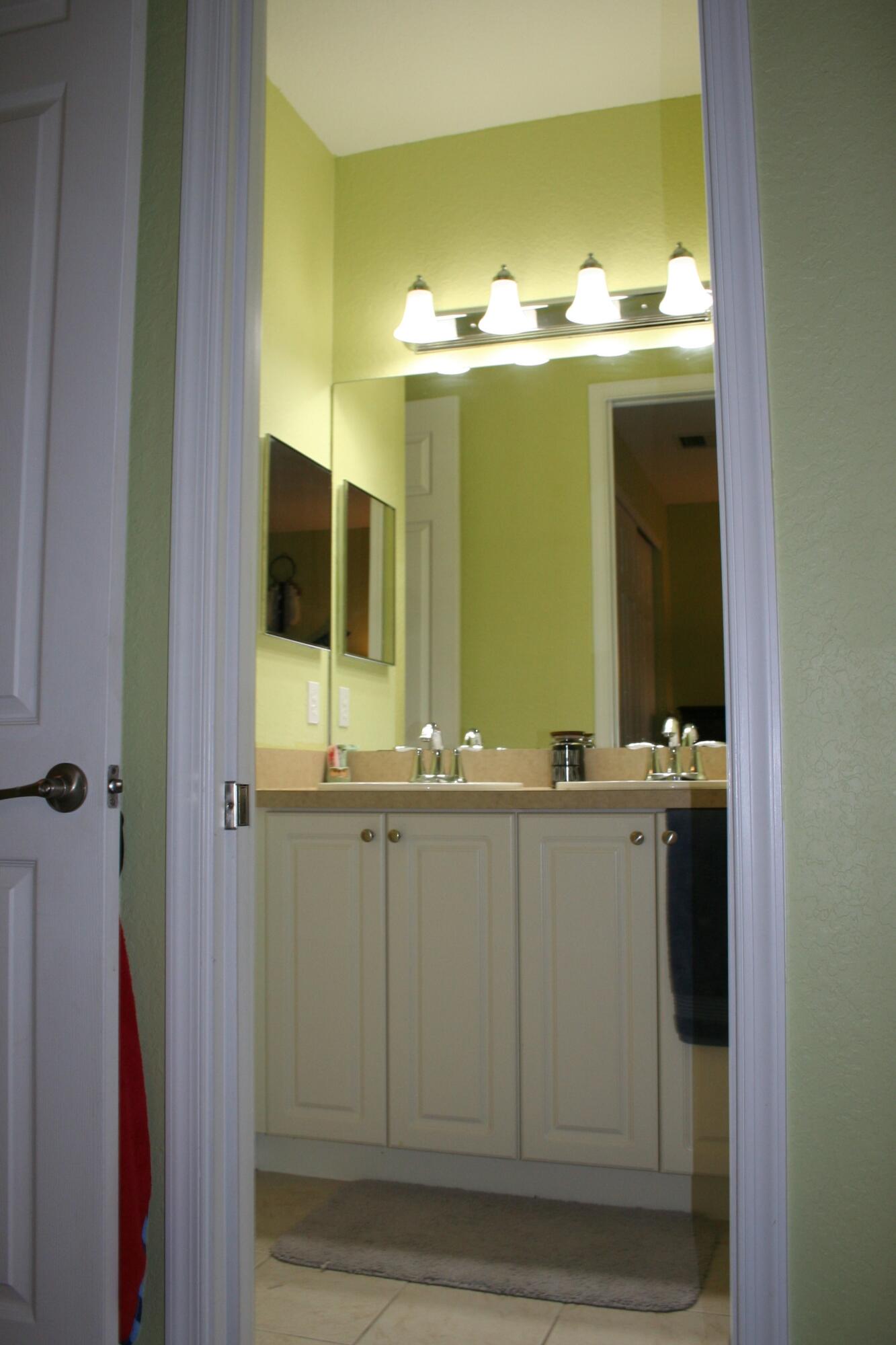 9469 Southwest Purple Martin Way Stuart, FL 34997 - Photo 16 of 23 a bathroom with a sink and mirror