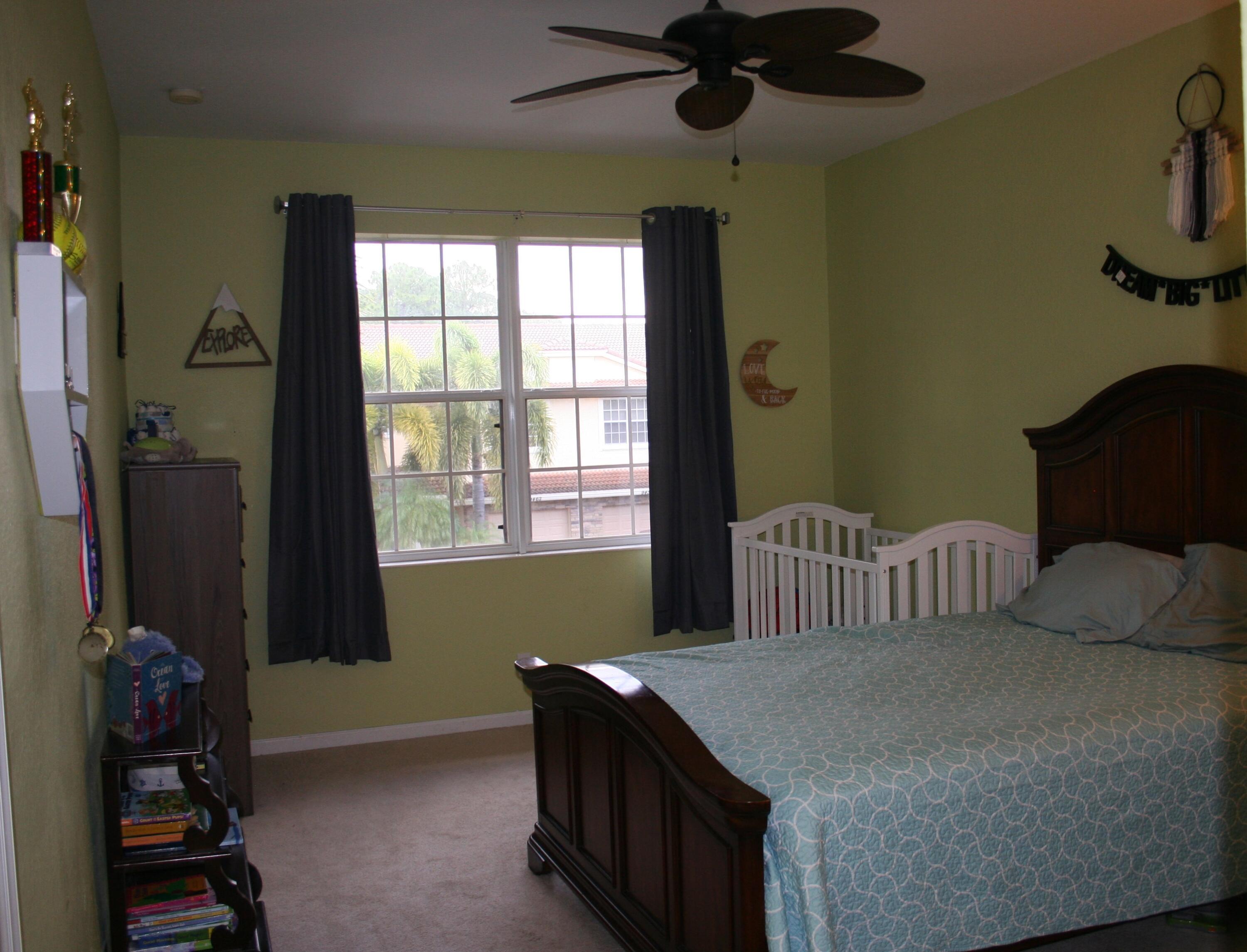 9469 Southwest Purple Martin Way Stuart, FL 34997 - Photo 19 of 23 a bedroom with a bed and a window