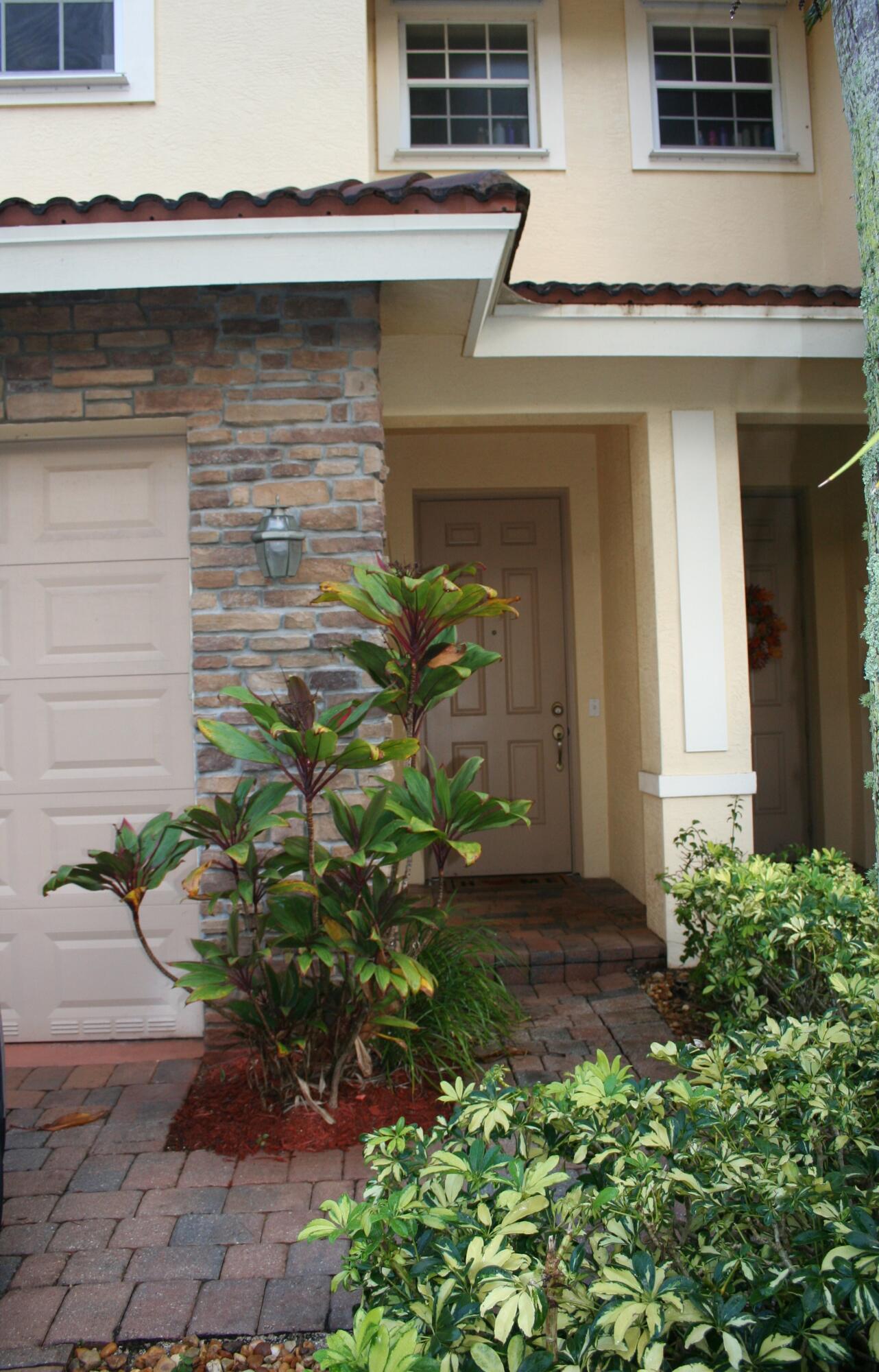9469 Southwest Purple Martin Way Stuart, FL 34997 - Photo 2 of 23 a front view of a house with a yard and garage