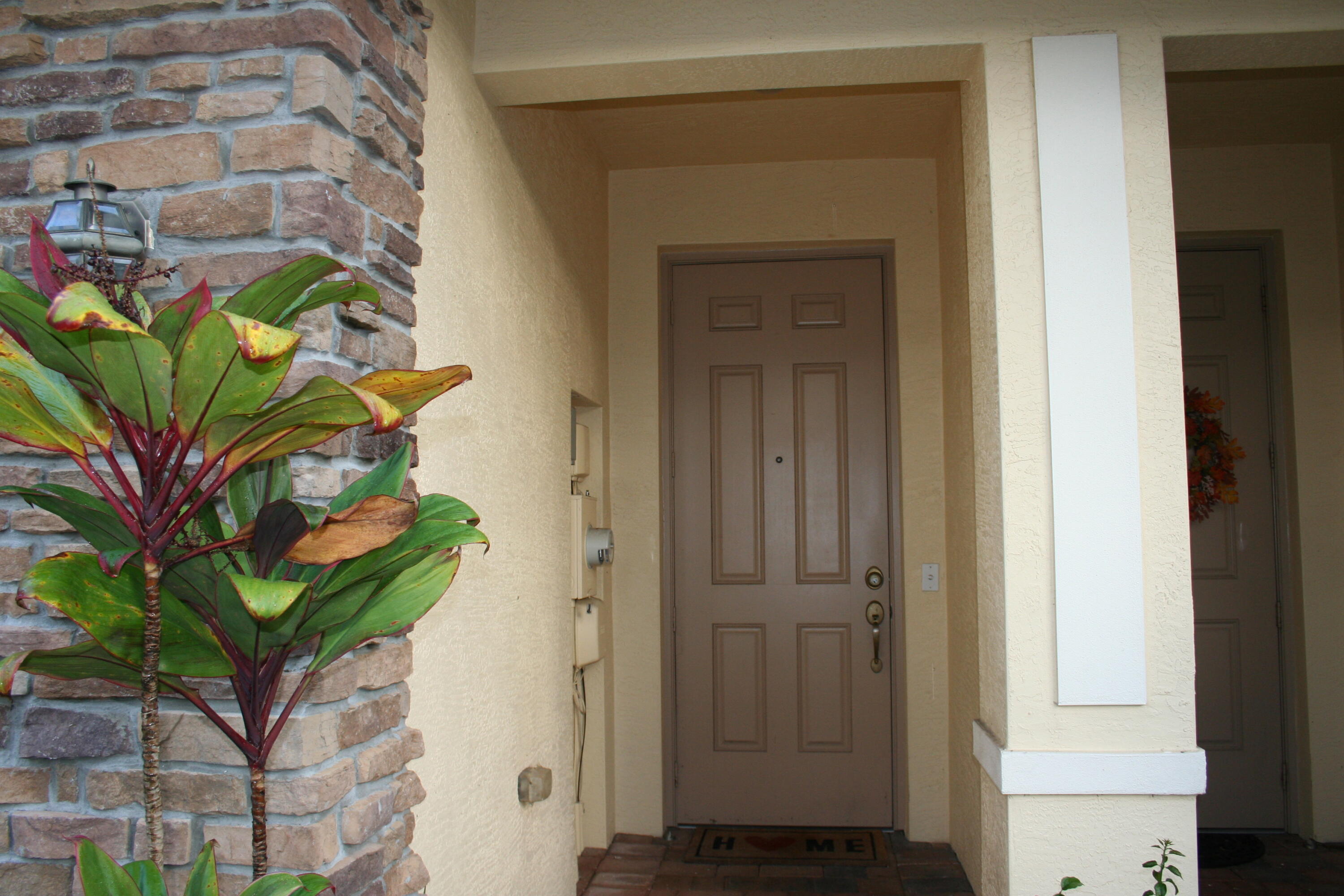 9469 Southwest Purple Martin Way Stuart, FL 34997 - Photo 3 of 23 a potted plant in front of a door
