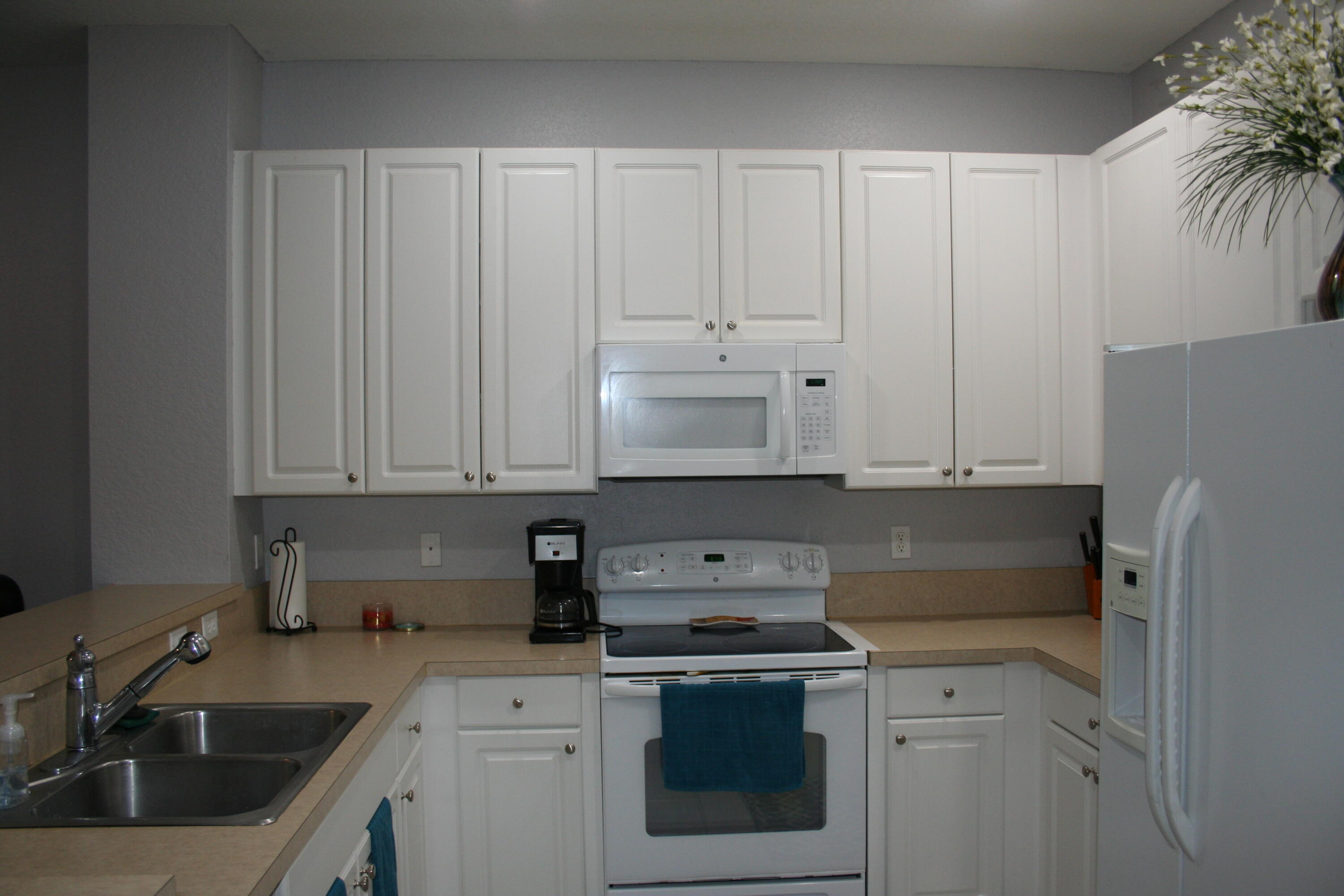 9469 Southwest Purple Martin Way Stuart, FL 34997 - Photo 7 of 23 a kitchen with a sink stove and cabinets