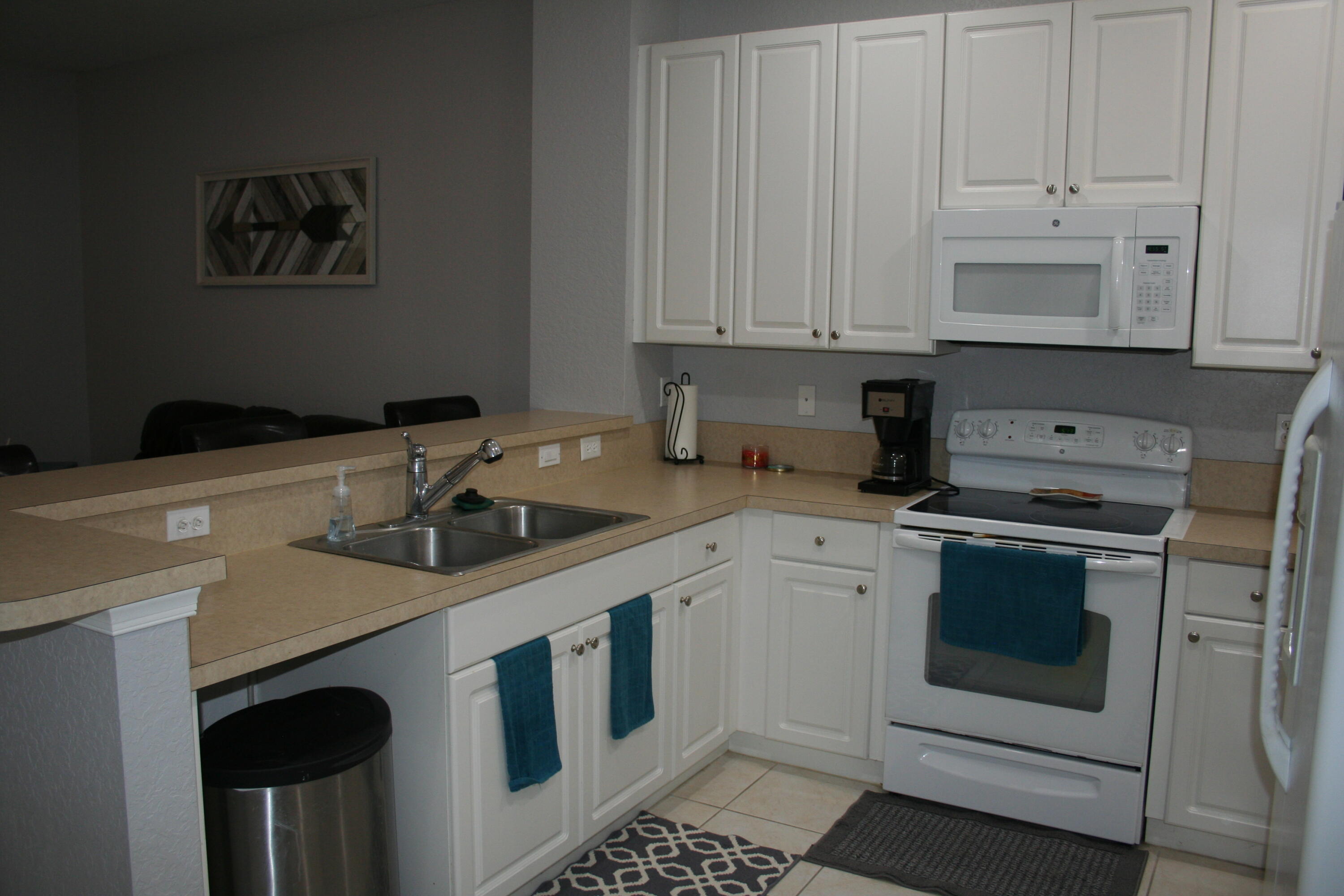 9469 Southwest Purple Martin Way Stuart, FL 34997 - Photo 8 of 23 a kitchen with granite countertop white cabinets and white appliances
