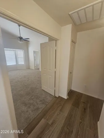 en empty room with windows and chandelier fan