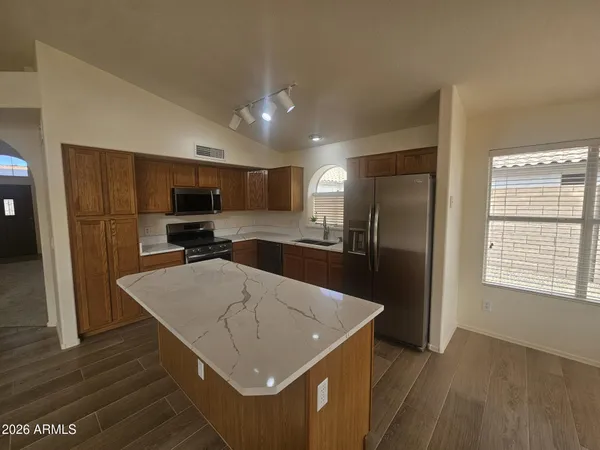 a kitchen with a refrigerator a sink dishwasher and a stove with wooden floor