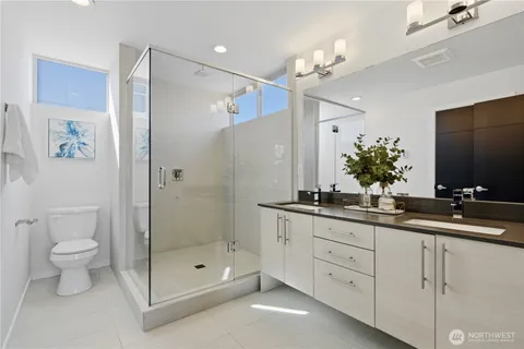 a bathroom with a double vanity sink mirror and toilet