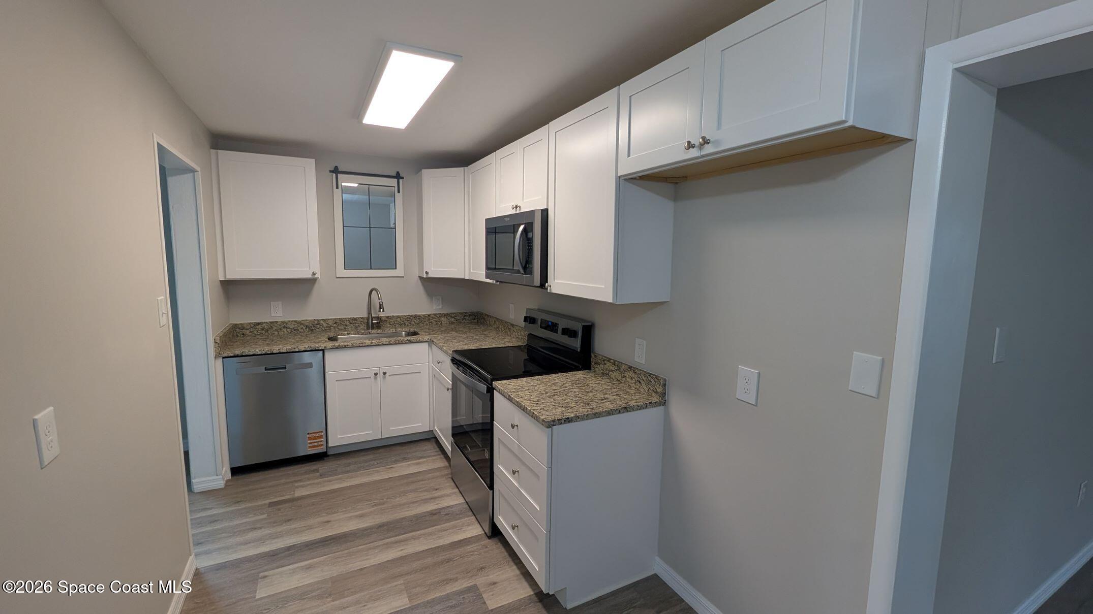 108 1st Street Merritt Island, FL 32953 - Photo 13 of 40 a kitchen with a sink stove and microwave