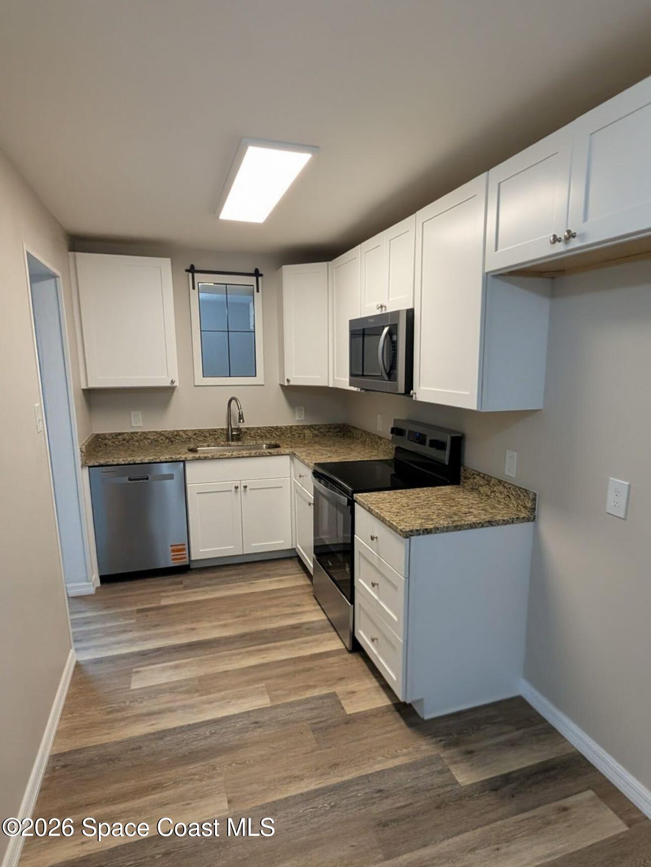 108 1st Street Merritt Island, FL 32953 - Photo 14 of 40 a kitchen with stainless steel appliances granite countertop a stove a sink and a microwave