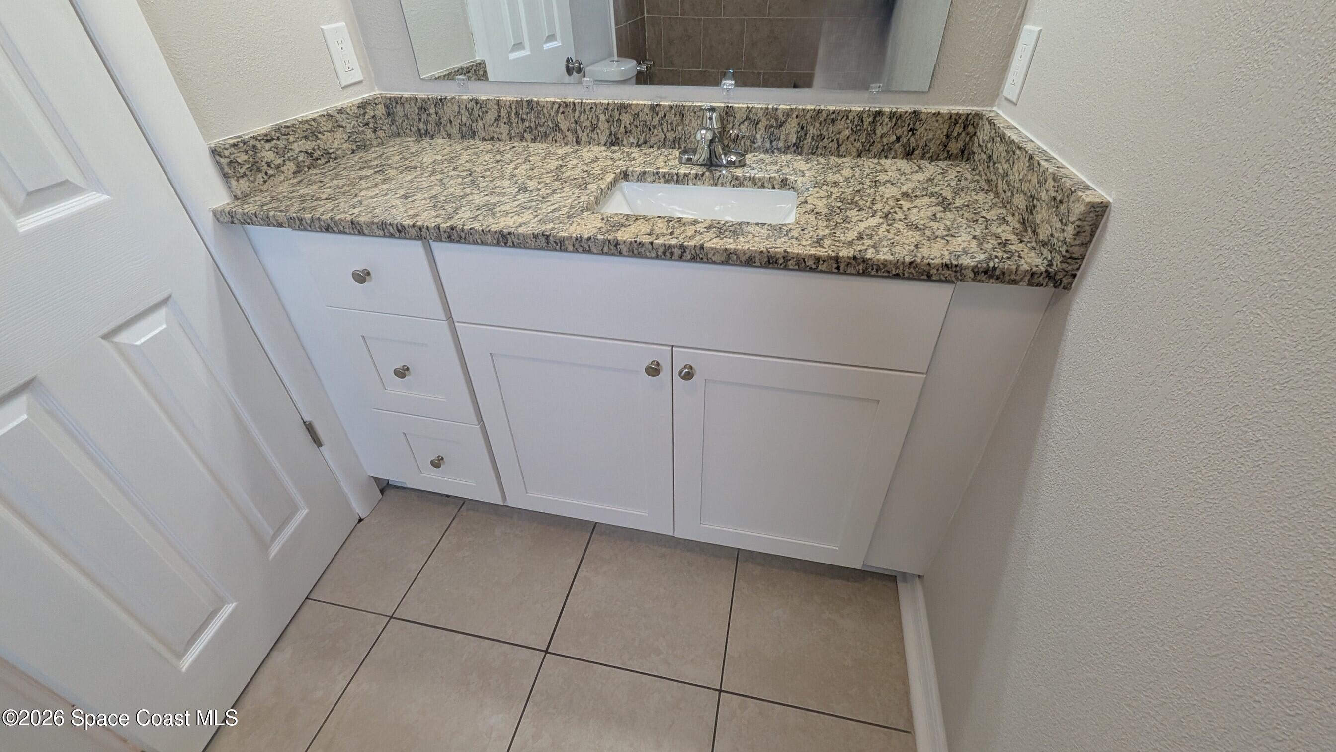 108 1st Street Merritt Island, FL 32953 - Photo 21 of 40 a bathroom with a granite countertop sink and a mirror