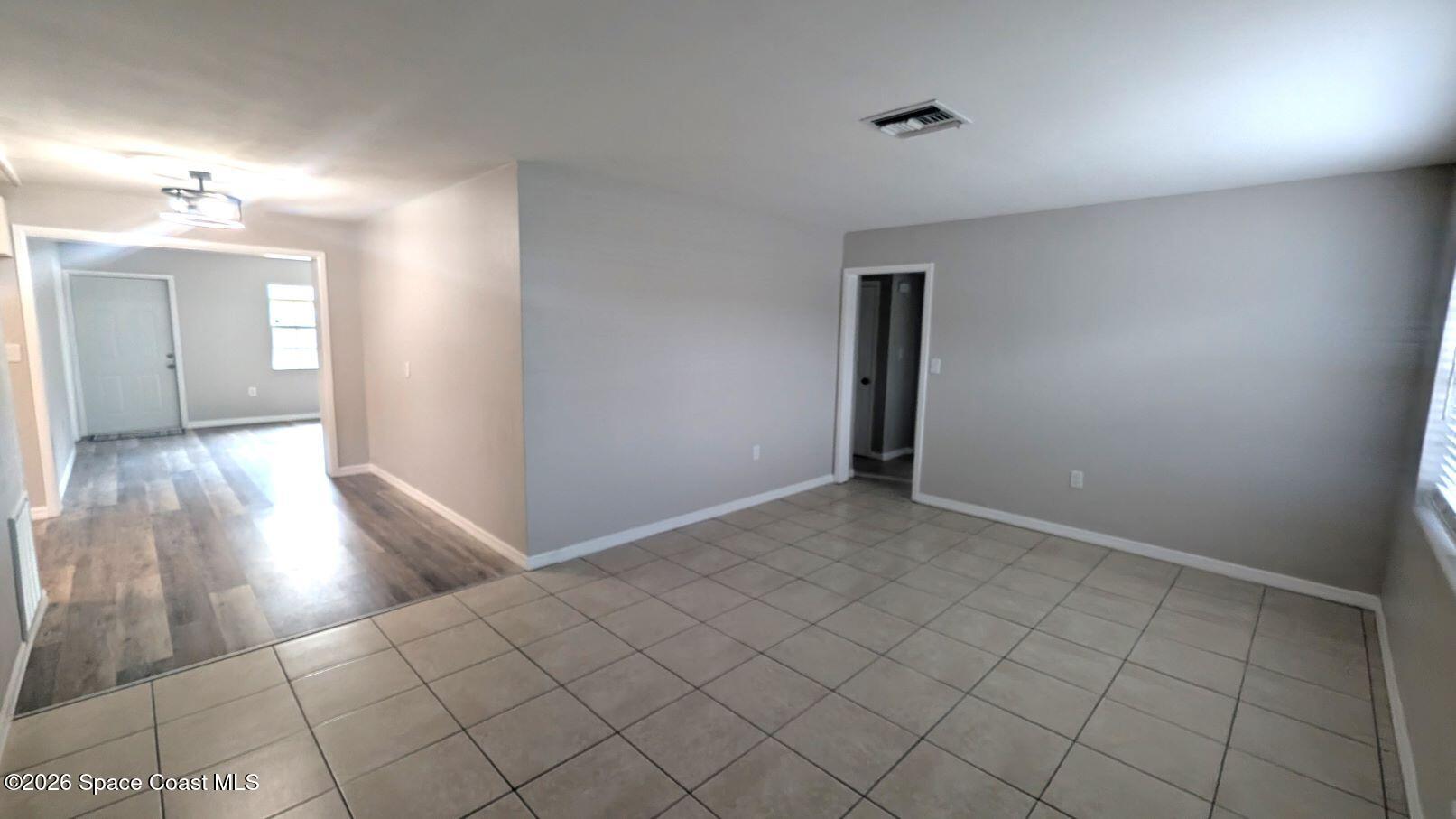 108 1st Street Merritt Island, FL 32953 - Photo 8 of 40 an empty room with wooden floor and bathroom