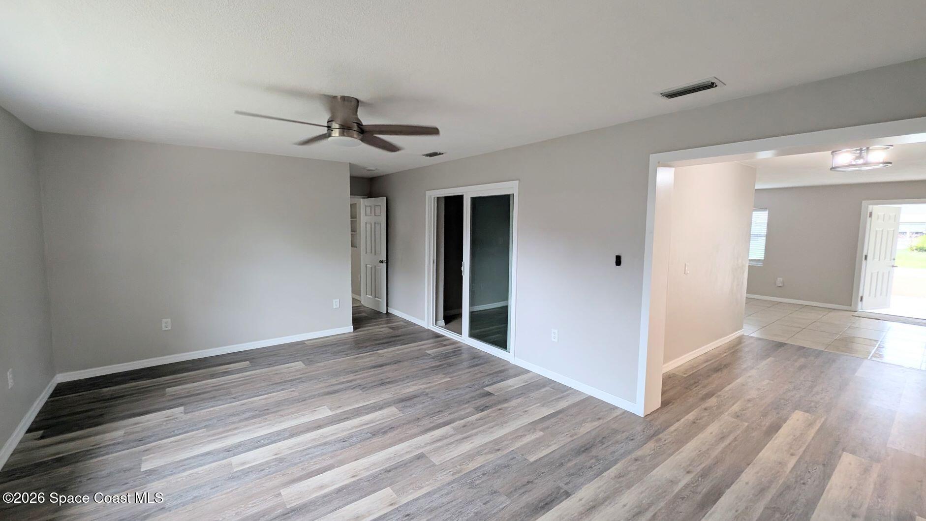 108 1st Street Merritt Island, FL 32953 - Photo 9 of 40 a view of a livingroom with wooden floor and a ceiling fan