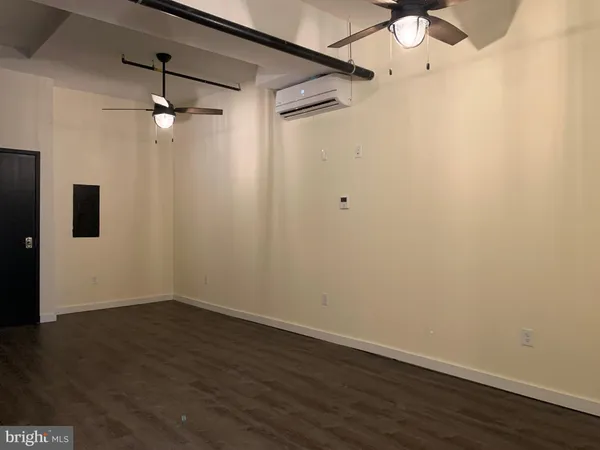 a view of a small space with wooden floor and fan