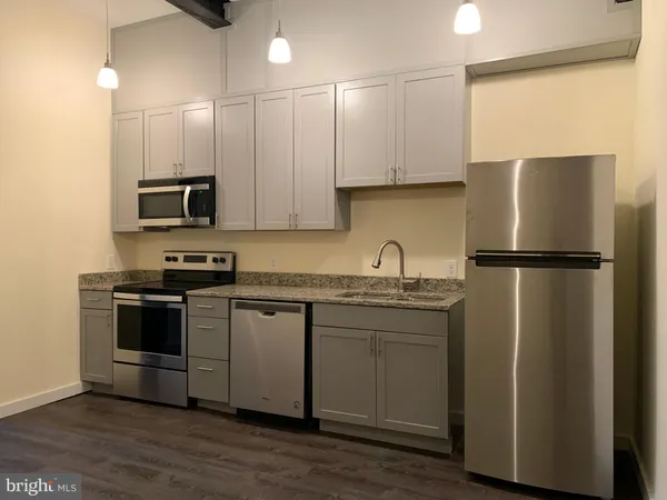 a kitchen with stainless steel appliances granite countertop a refrigerator stove a sink and a microwave