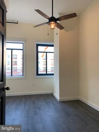 an empty room with a window and a fan