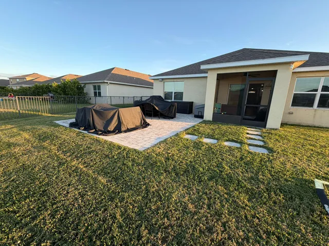a view of a house with backyard and sitting area