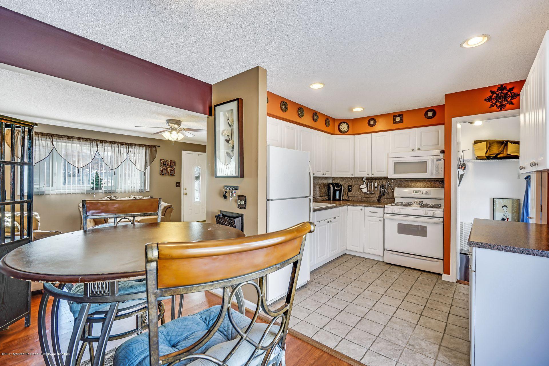 36 Mallard Road Bayville, NJ 08721 - Photo 8 of 28 a kitchen with stainless steel appliances kitchen island granite countertop a stove a refrigerator a kitchen island with a stove and white cabinets