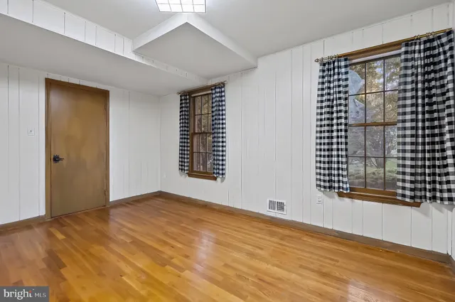 a view of an empty room with wooden floor