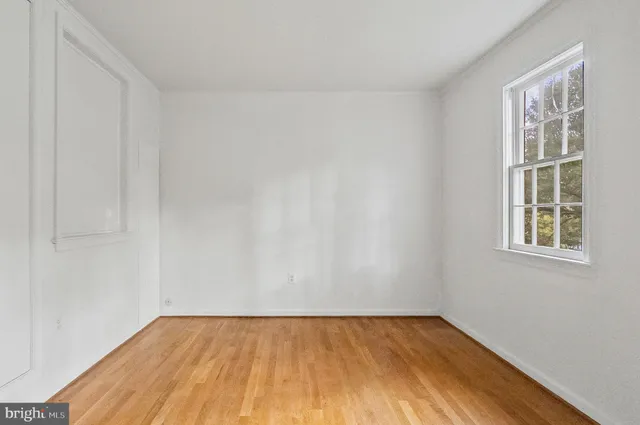 a view of empty room with wooden floor