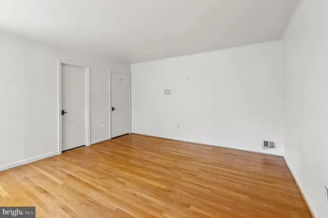a view of an empty room with wooden floor