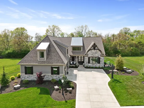 a front view of a house with yard and green space