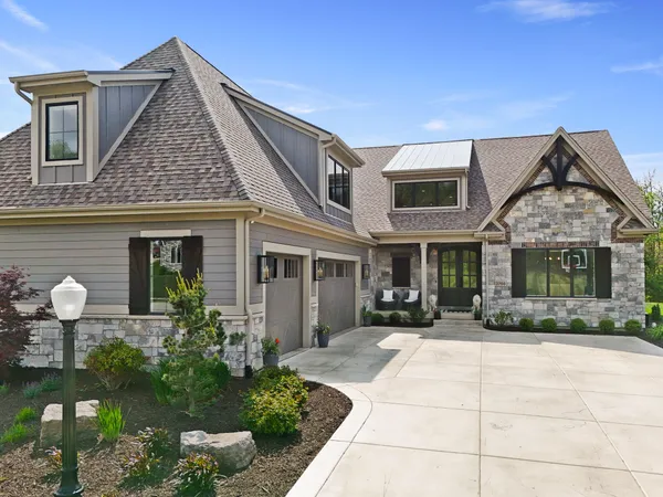 a front view of a house with yard and parking