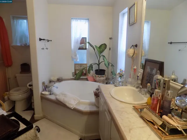 a bathroom with a granite countertop sink a toilet and a mirror
