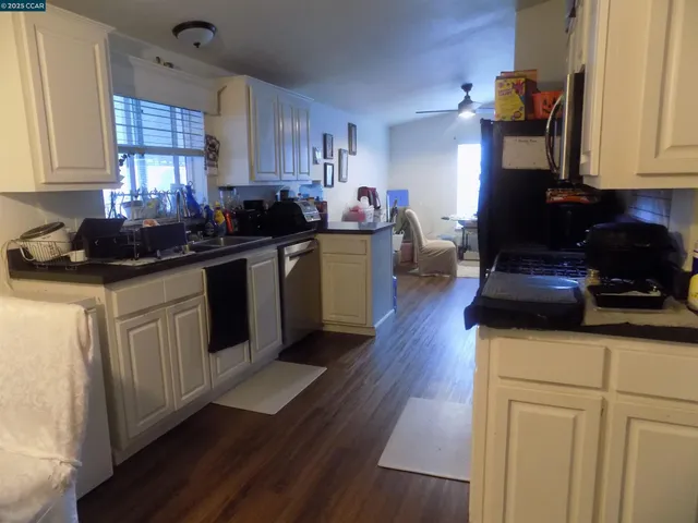 a kitchen with a sink cabinets and wooden floor