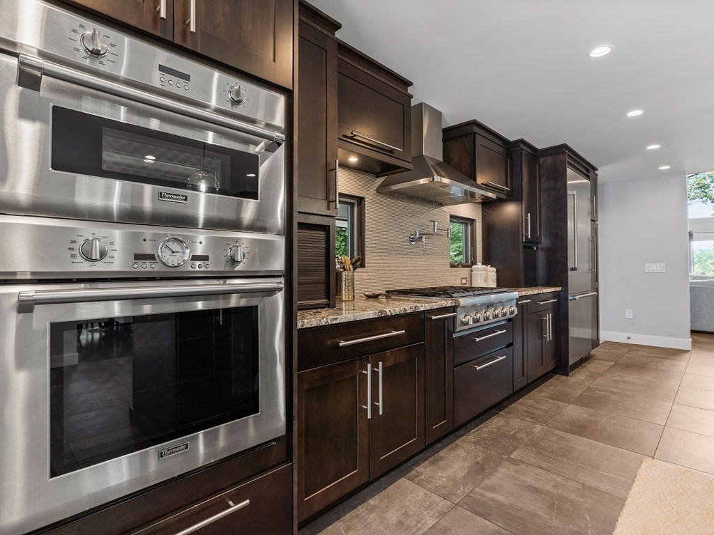 49 Reed Street Rehoboth, MA 02769 - Photo 4 of 40 a kitchen with stainless steel appliances granite countertop wooden cabinets and a stove top oven