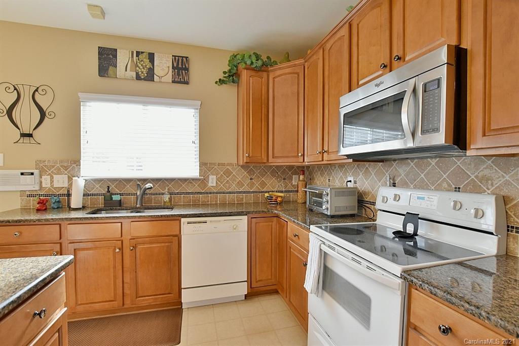 6306 Hawks Eye Court Fort Mill, SC 29708 - Photo 11 of 26 a kitchen with granite countertop a sink a stove and cabinets