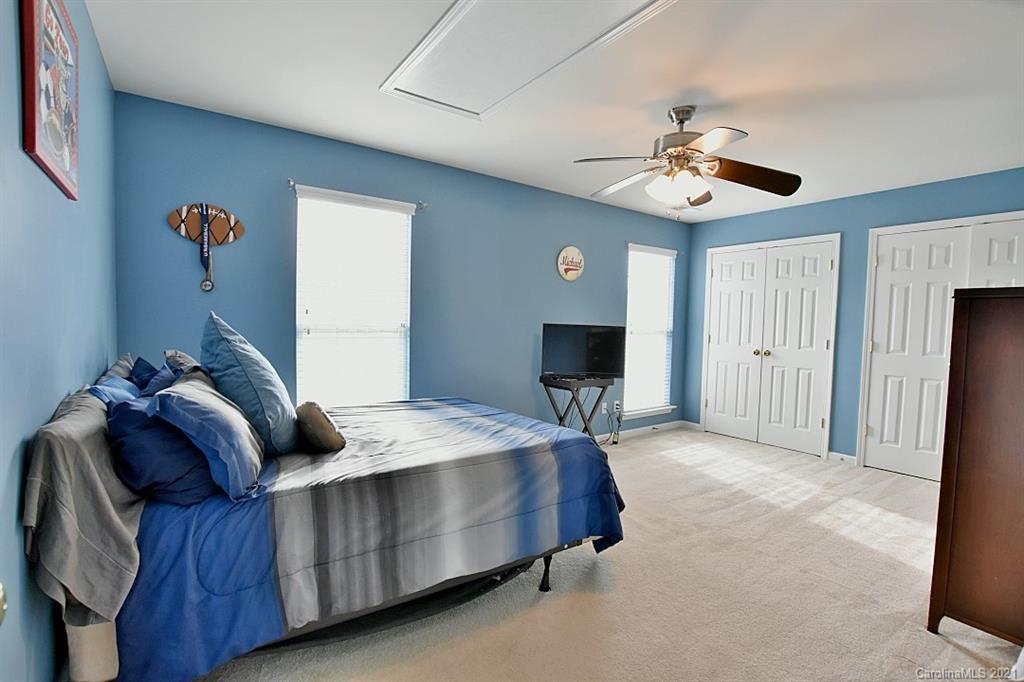 6306 Hawks Eye Court Fort Mill, SC 29708 - Photo 20 of 26 a spacious bedroom with a bed and a chandelier