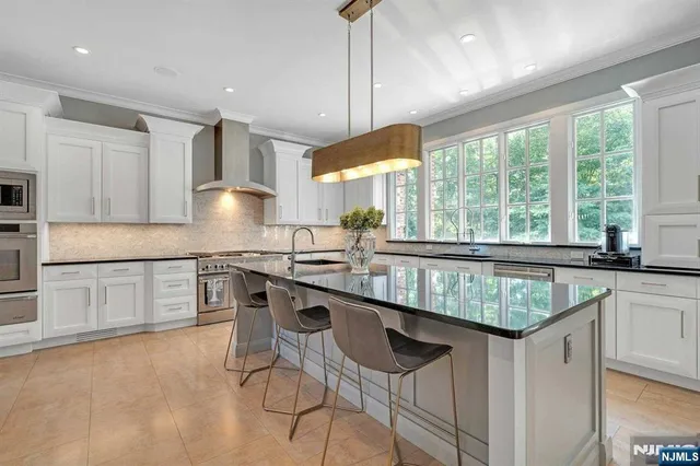 a kitchen with kitchen island granite countertop a sink and a stove
