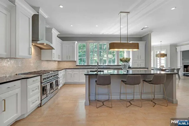a kitchen with granite countertop a stove a sink a counter space and dining table