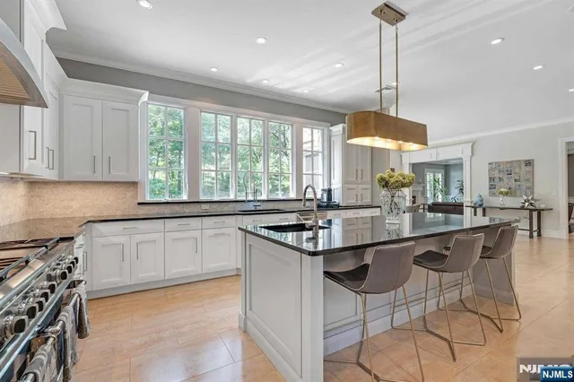 a kitchen with stainless steel appliances granite countertop a stove a sink and a wooden floor