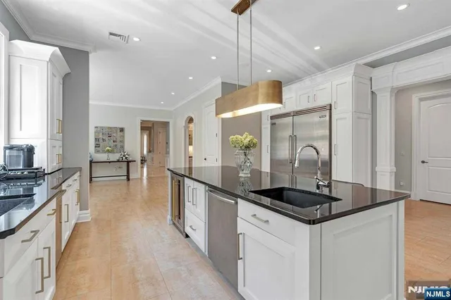 a kitchen with stainless steel appliances granite countertop a sink a stove and a refrigerator