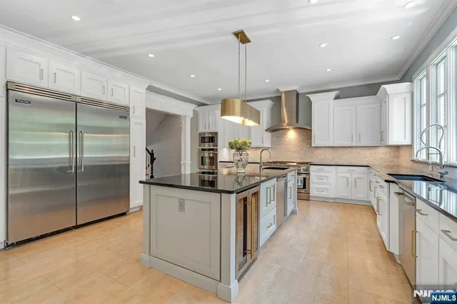 a kitchen with stainless steel appliances granite countertop a stove a sink and a refrigerator