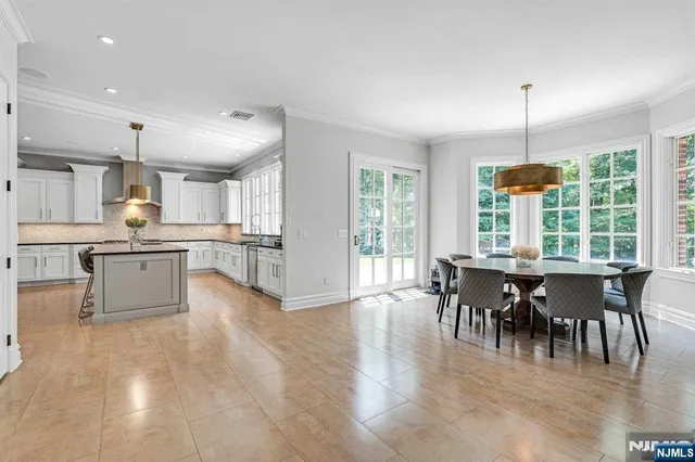 a view of a dining room and livingroom with furniture wooden floor a chandelier