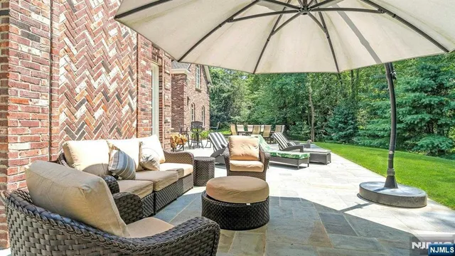 a patio with a table and chairs under an umbrella