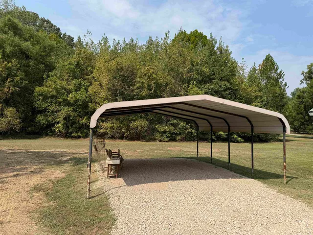 a view of a yard with a bench in the background