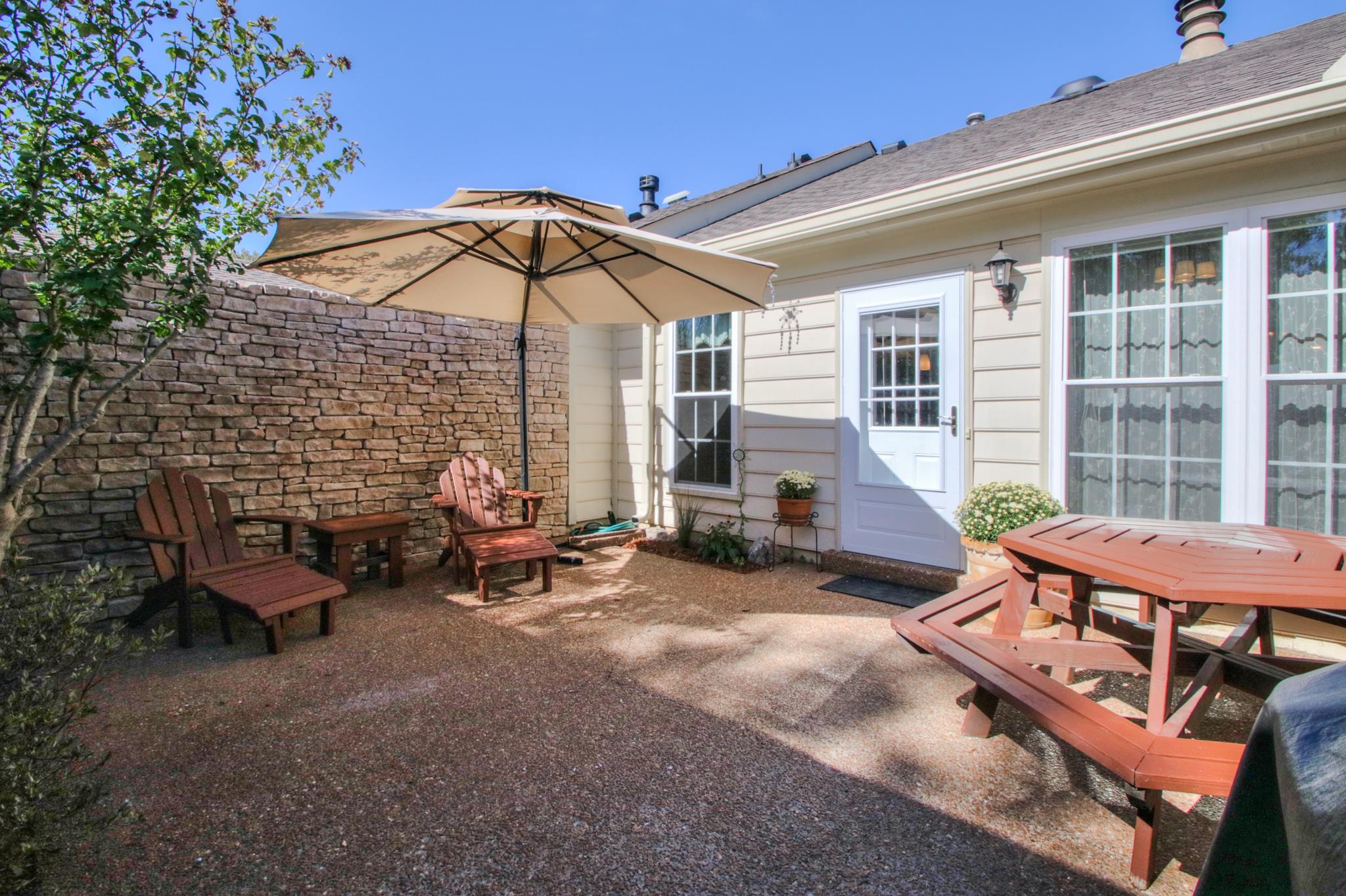1031 General George Patton Road, Unit 1031 Nashville, TN 37221 - Photo 3 of 14 a view of a patio with a table and chairs under an umbrella