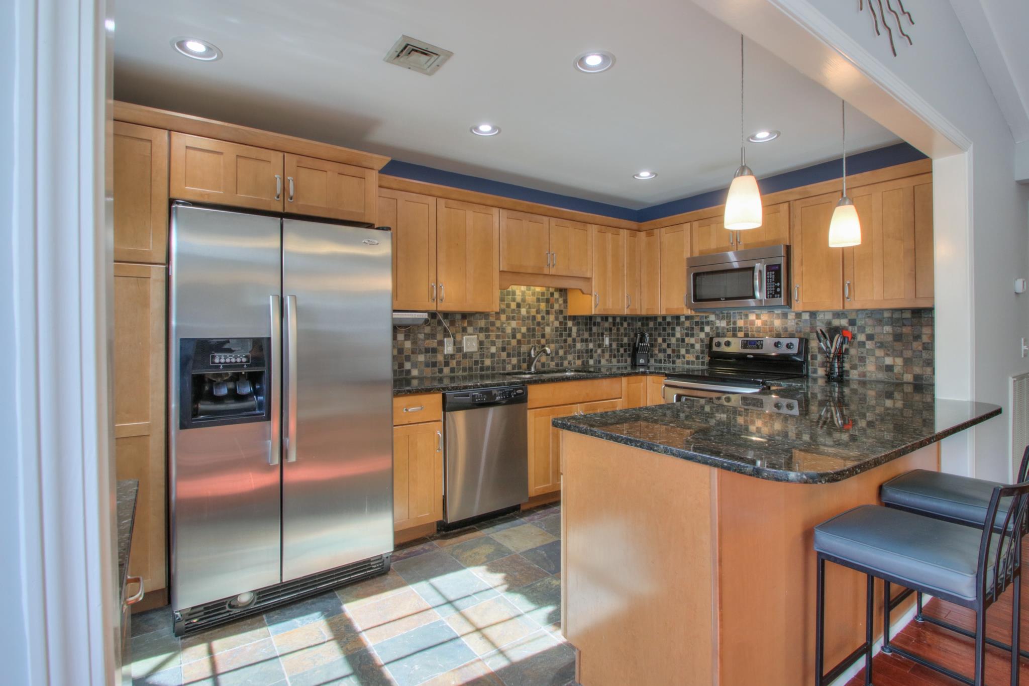 1031 General George Patton Road, Unit 1031 Nashville, TN 37221 - Photo 8 of 14 a kitchen with stainless steel appliances granite countertop a sink a stove and a refrigerator