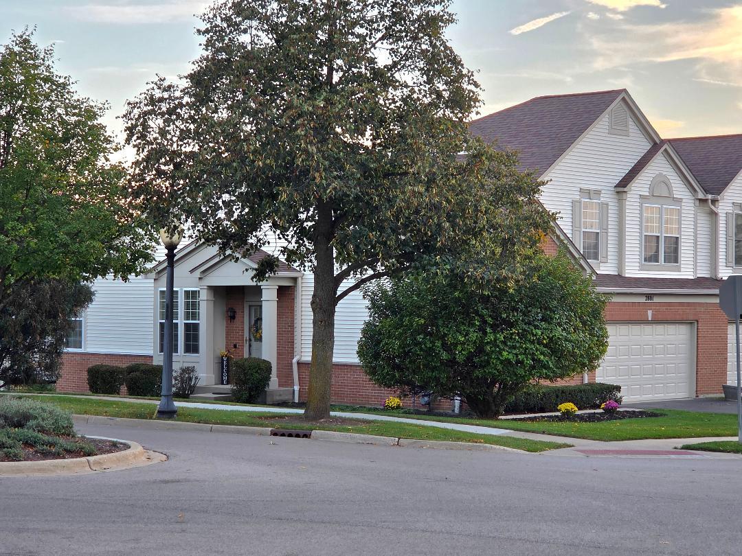 a front view of a house with a yard and trees