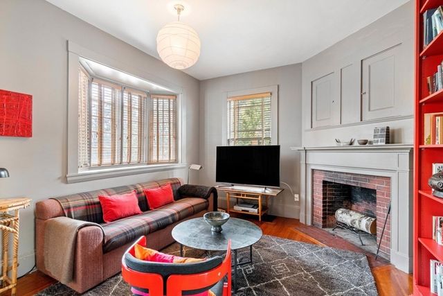 a living room with furniture a fireplace and a flat screen tv