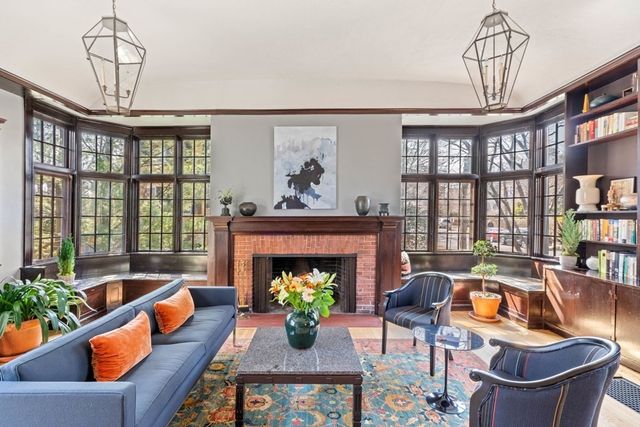 a living room with furniture a chandelier and a fireplace