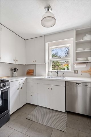a kitchen with a sink window and cabinets