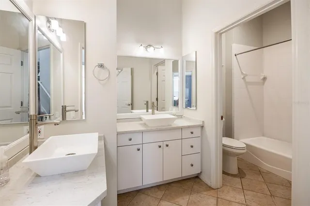 a spacious bathroom with a toilet sink and mirror
