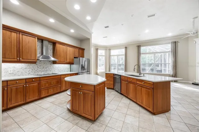 a large kitchen with stainless steel appliances granite countertop wooden cabinets a sink and dishwasher