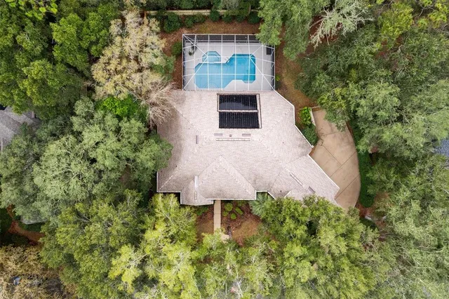 an aerial view of a house with a yard and large trees