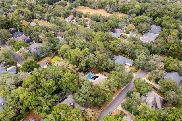 an aerial view of a houses with a yard and mountain view in back
