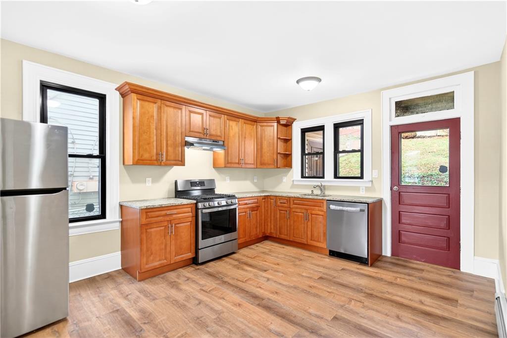 422 West 7th Avenue Tarentum, PA 15084 - Photo 11 of 50 a large kitchen with stainless steel appliances granite countertop a stove a sink dishwasher a refrigerator and a stove with wooden floor