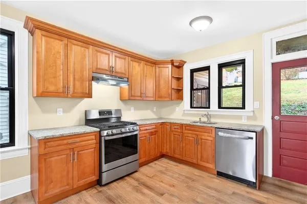 a kitchen with stainless steel appliances granite countertop a stove sink and cabinets