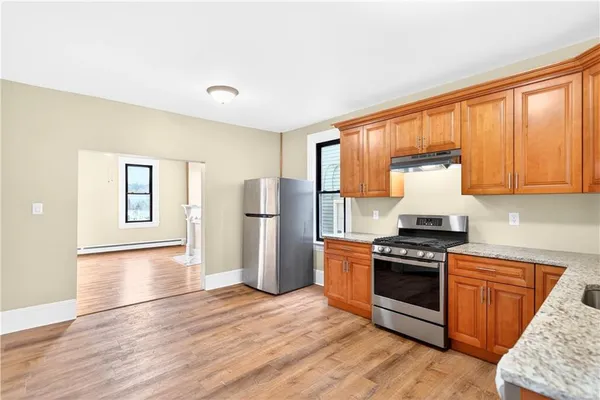 a kitchen with wooden floors and stainless steel appliances
